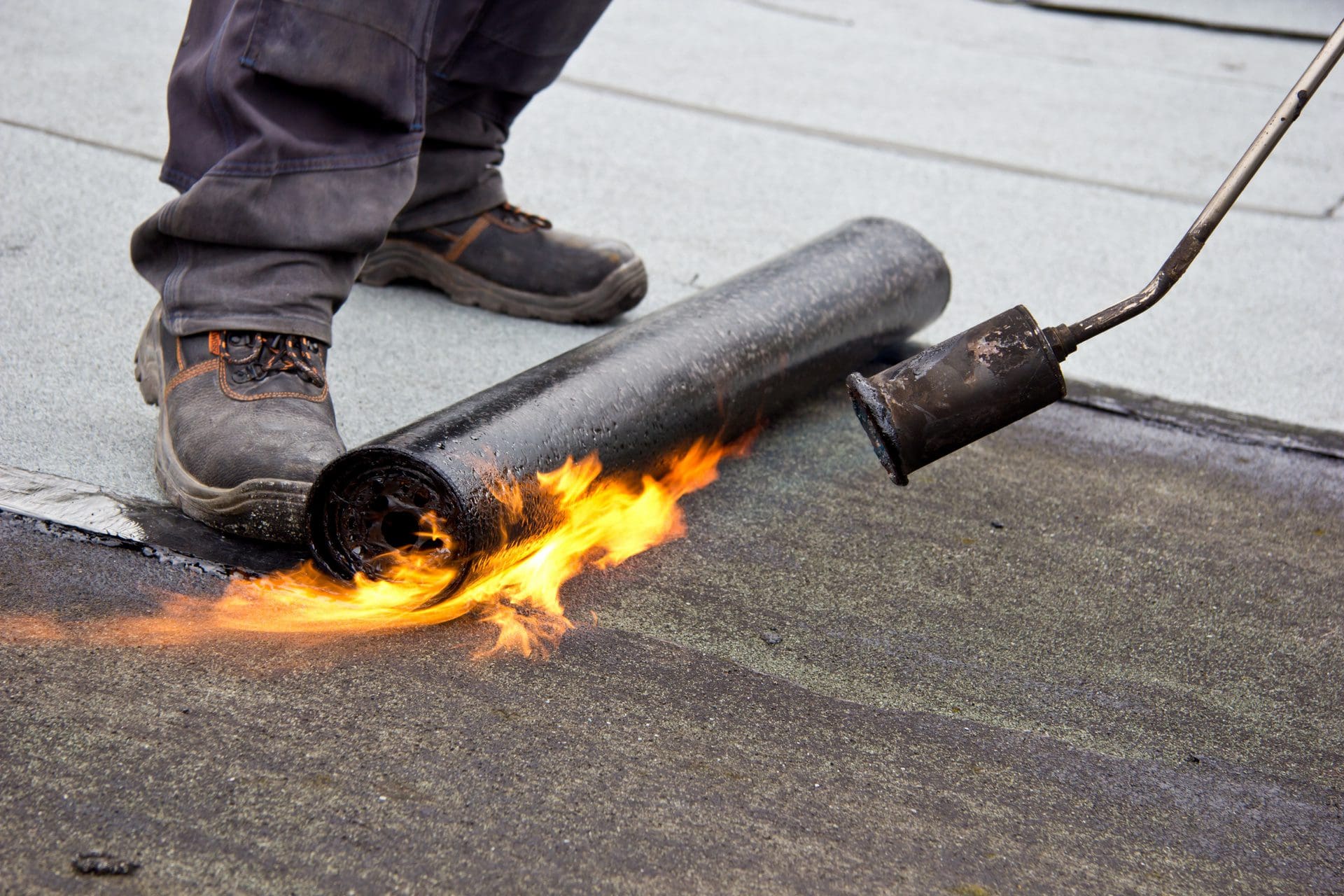 Dachdecker bei der Flachdach Reparatur | Mit welchen Kosten muss man rechnen, wenn man sein Flachdach sanieren will? (© Deminos / stock.adobe.com)