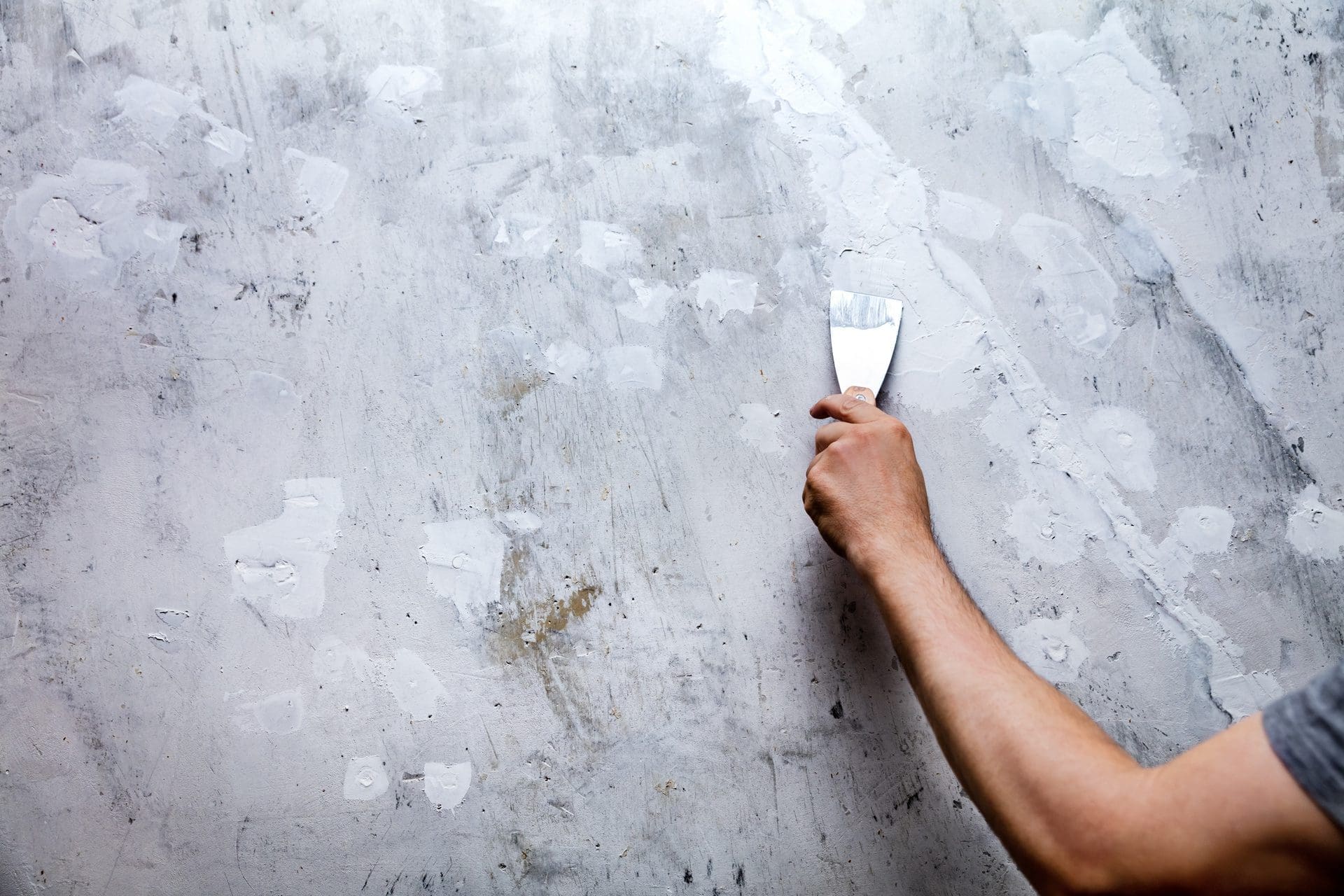 Löcher und Risse in einer Wand werden mit Füllmaterial oder Gips zugespachtelt - aber ist die Ursache geklärt?! (© M. Dörr & M. Frommherz / stock.adobe.com)