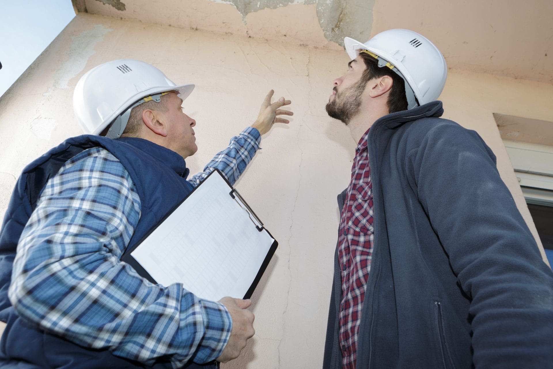 Zwei Sachverständige / Gutachter für Feuchteschäden bewerten einen Schaden am Haus (© auremar / stock.adobe.com)